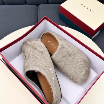These Marni Fussbett Sabot slippers feature a beige long hair calfskin upper with a relaxed slip on mule design and a branded leather insole The distinctive texture and neutral color create a refined look for casual styling