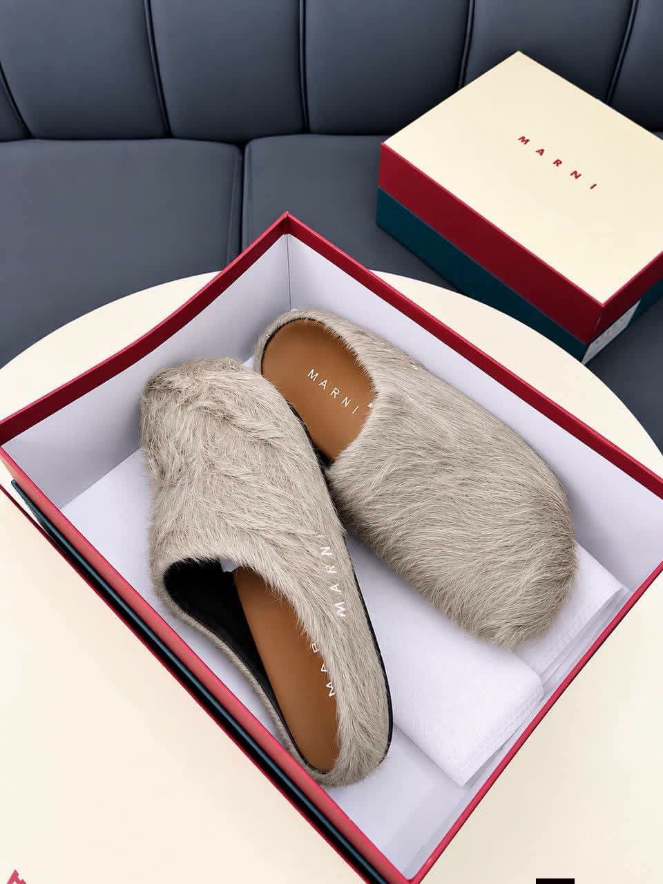 These Marni Fussbett Sabot slippers feature a beige long hair calfskin upper with a relaxed slip on mule design and a branded leather insole The distinctive texture and neutral color create a refined look for casual styling These Marni Fussbett Sabot slippers feature a beige long hair calfskin upper with a relaxed slip on mule design and a branded leather insole The distinctive texture and neutral color create a refined look for casual styling